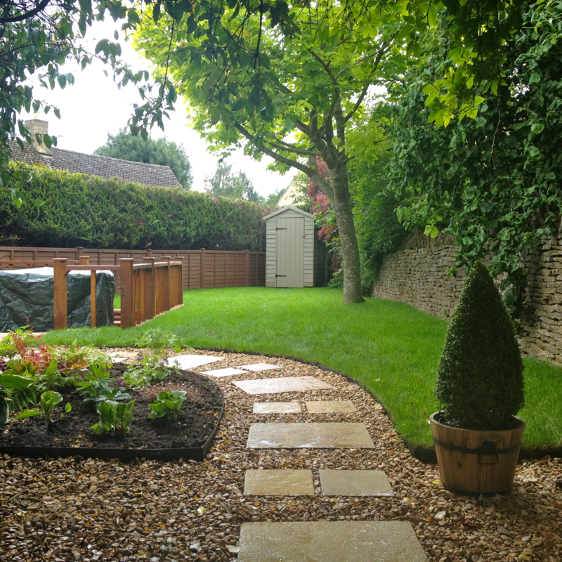 A stepping stone path set into gravel with metal edging.