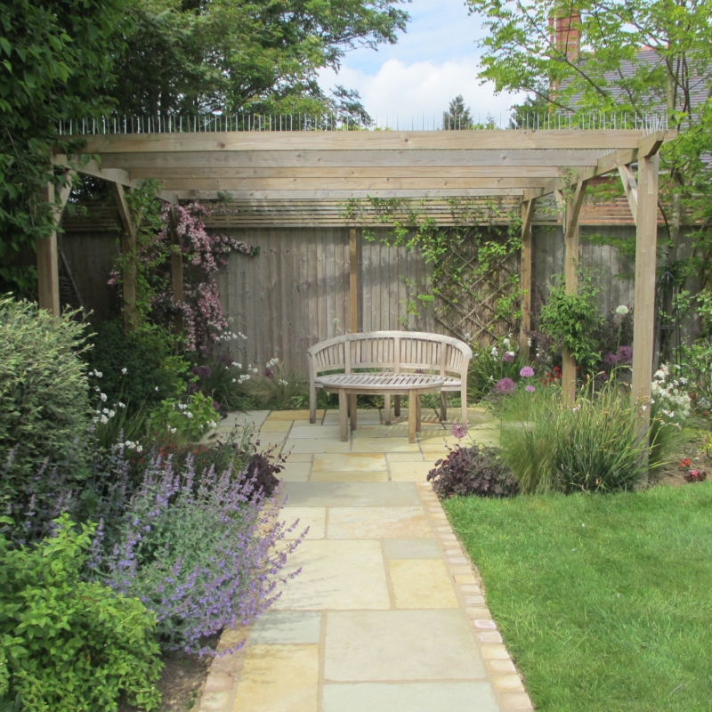 Path leading to a seating area under a pergola.