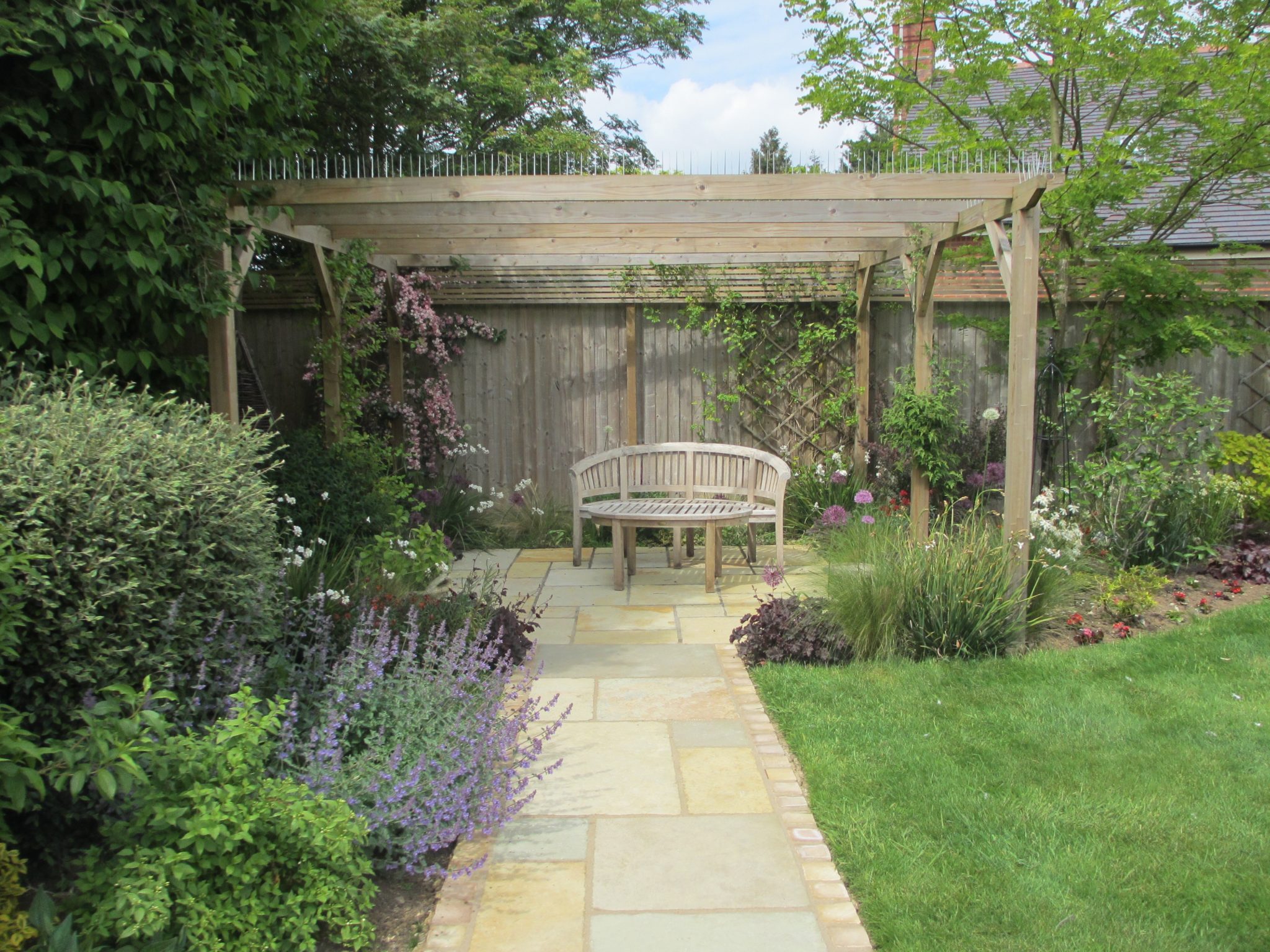 Path leading to a seating area under a pergola.